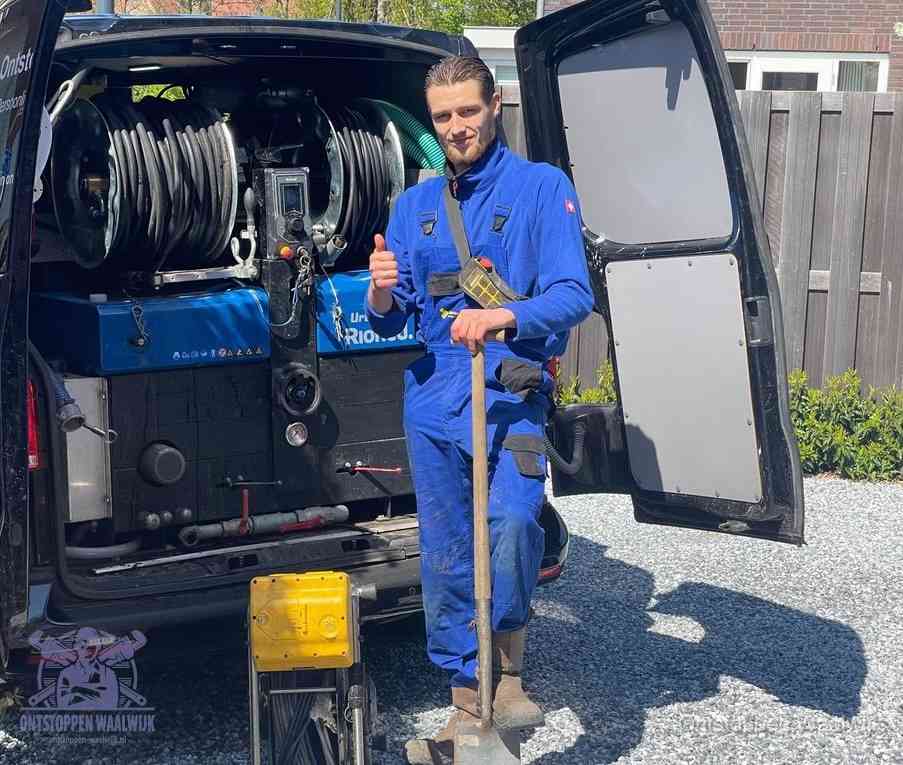 Een monteur bij de werkbus met grote hogedruk-slanghaspels, apparatuur voor hardnekkige afvoerverstoppingen in Waalwijk